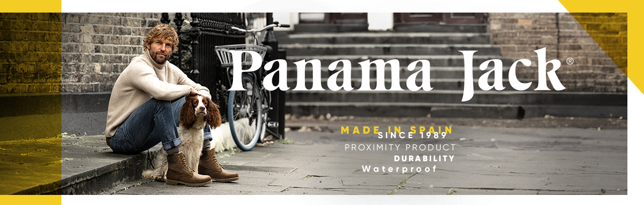 Mann sitzt vor eine Tür und trägt Panama Jack Sandalen