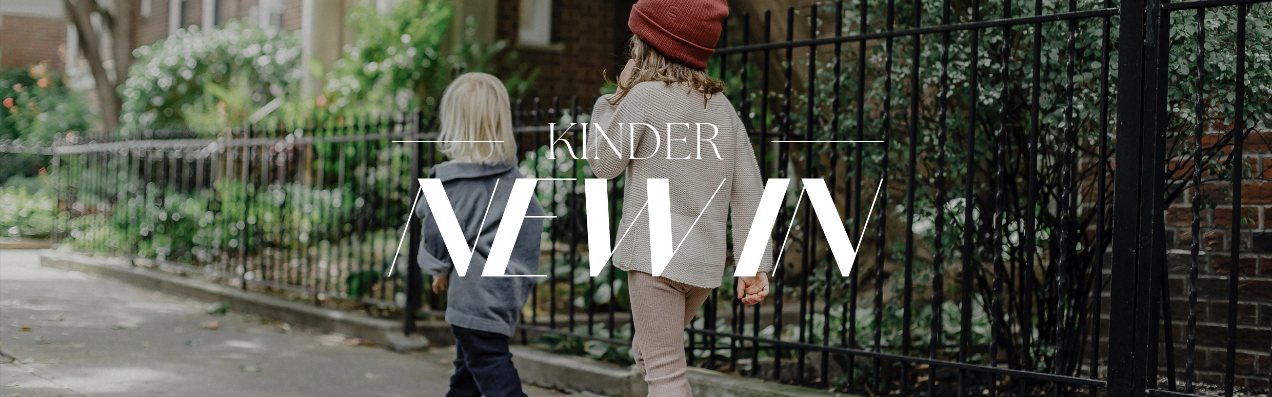 Schriftzug NEW IN im Hintergrund Kinder